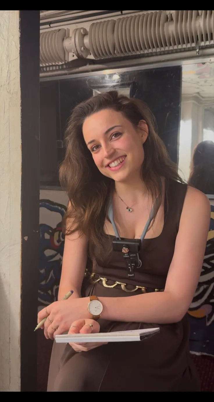Anne Leblanc, carnet et crayon à la main, souriante