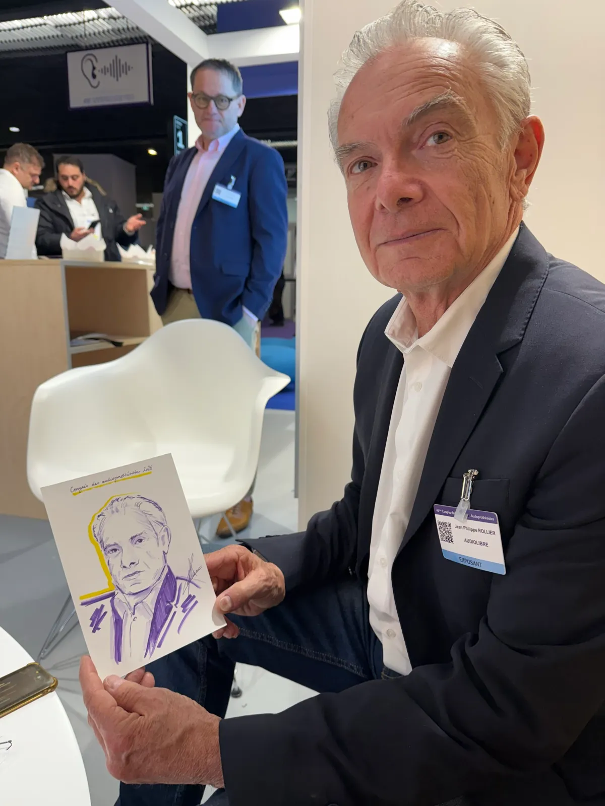 Jean-Philippe tient fièrement le portrait qu'Anne vient de dessiner de lui